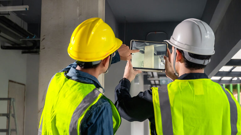 Engineers using a tablet to inspect a building site interior