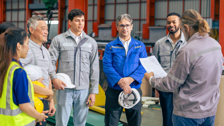 Factory team listening to a supervisor during a safety briefing