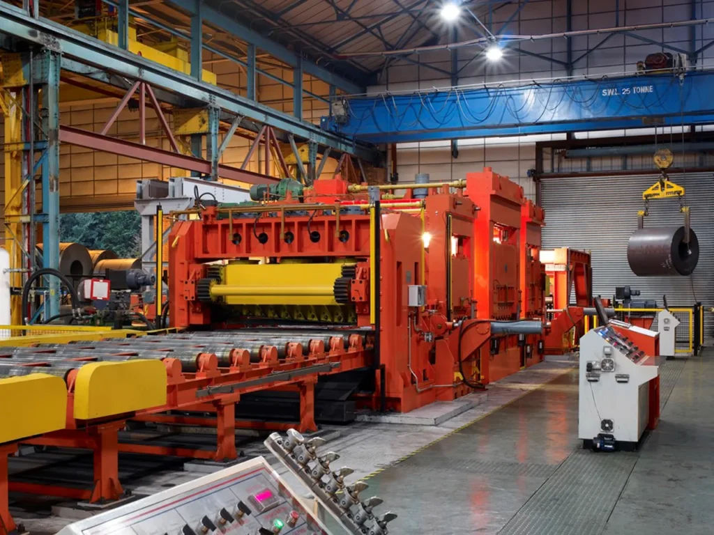 Large industrial machine in a factory with metal coils and safety equipment