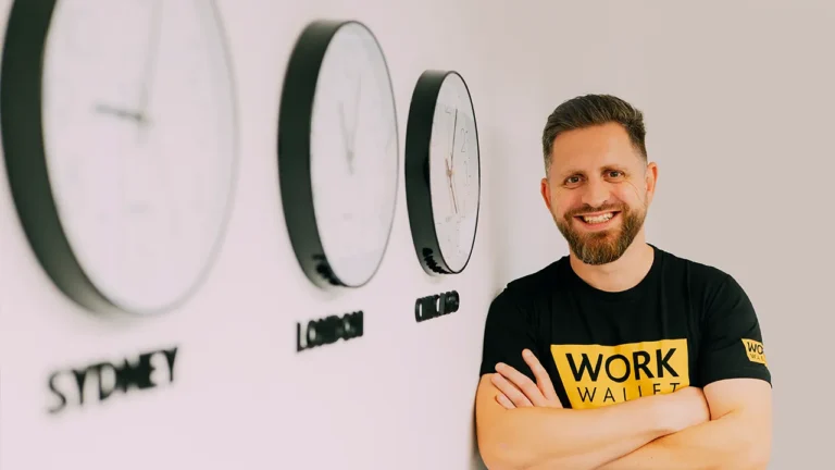 Person in Work Wallet shirt smiling beside world clocks labelled Sydney, London, Chicago
