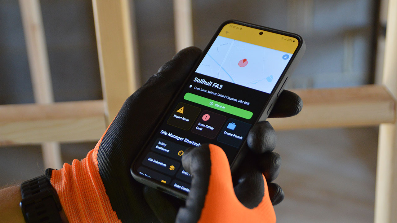 Gloved worker holding a smartphone displaying the Work Wallet safety app