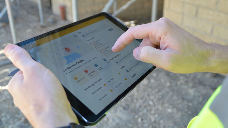 Person using a tablet showing a site safety management dashboard
