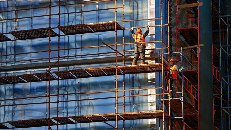 Workers on scaffolding outside a building during construction