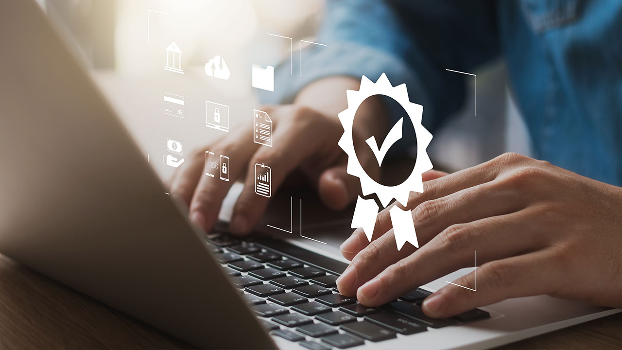 Person typing on laptop with digital quality certification icons overlay