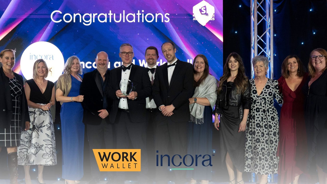 Group celebrating award win on stage with congratulations screen behind