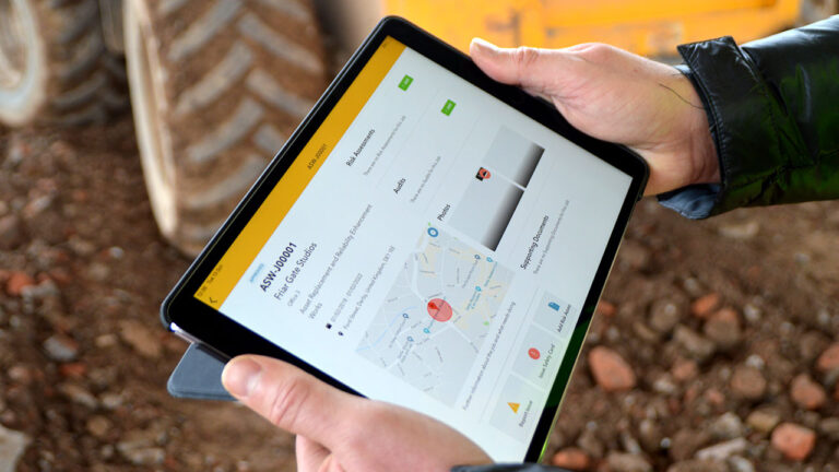 A person holds a tablet displaying a Work Wallet site dashboard
