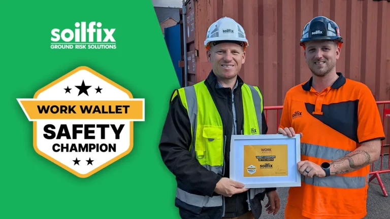 Two Soilfix workers in safety gear holding a Work Wallet Safety Champion award