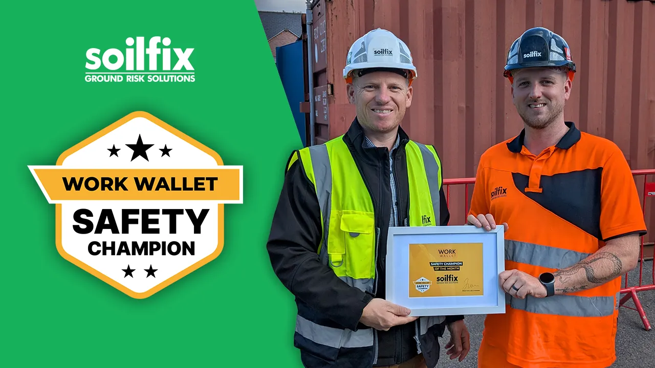 Two Soilfix workers in safety gear holding a Work Wallet Safety Champion award