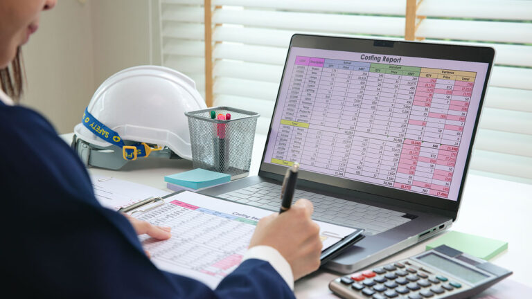 Office worker reviewing costing report spreadsheet on a laptop