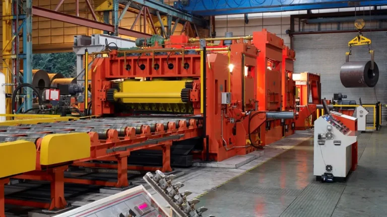 Large industrial machine in a factory with metal coils and safety equipment