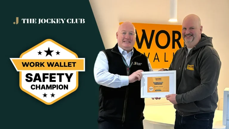 Two men smiling as one hands the other a framed Work Wallet Safety Champion award